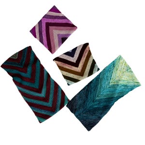 May include: An assortment of handmade knitted shawls in various colors. The shawls feature a chevron pattern in shades of teal, burgundy, purple, brown, and blue. The shawls are displayed against a white background.
