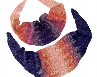 Könnte beinhalten: Zwei halbmondförmige Strickschals mit Zickzackmuster. Das Garn verläuft farblich von Dunkelviolett über Magenta und Pink bis hin zu hellem Pfirsich. Die Strickstruktur weist durchgehend feine Lochmusterdetails im Gewebe auf.