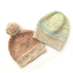 May include: Two knitted hats, one with a pom-pom on top. The hat with the pom-pom is orange and white, while the other hat is green and white.
