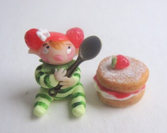 Tiny strawberry pixie figurine with faux victoria sponge cake