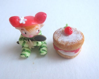 Tiny strawberry pixie figurine with faux victoria sponge cake
