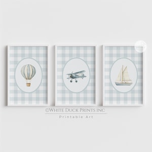 May include: Three framed prints featuring watercolor illustrations of a hot air balloon, biplane, and sailboat. Each image is set within an oval against a light blue and white gingham background. The text "©WHITE DUCK PRINTS INC Printable Art" is at the bottom.