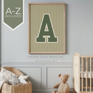 May include: A framed print with a large green letter A on a beige striped background. The text "White Duck Prints Inc. Printable Art" is below the image.