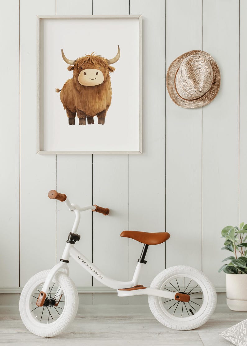 Peut inclure: Un v&eacute;lo d'&eacute;quilibre blanc avec un guidon et une selle en cuir marron. Le v&eacute;lo porte l'inscription "Ветер в волосах" sur le cadre. Le v&eacute;lo est devant un mur en bois blanc avec une estampe encadr&eacute;e d'une vache &eacute;cossaise brune et un chapeau de paille marron accroch&eacute; au mur.
