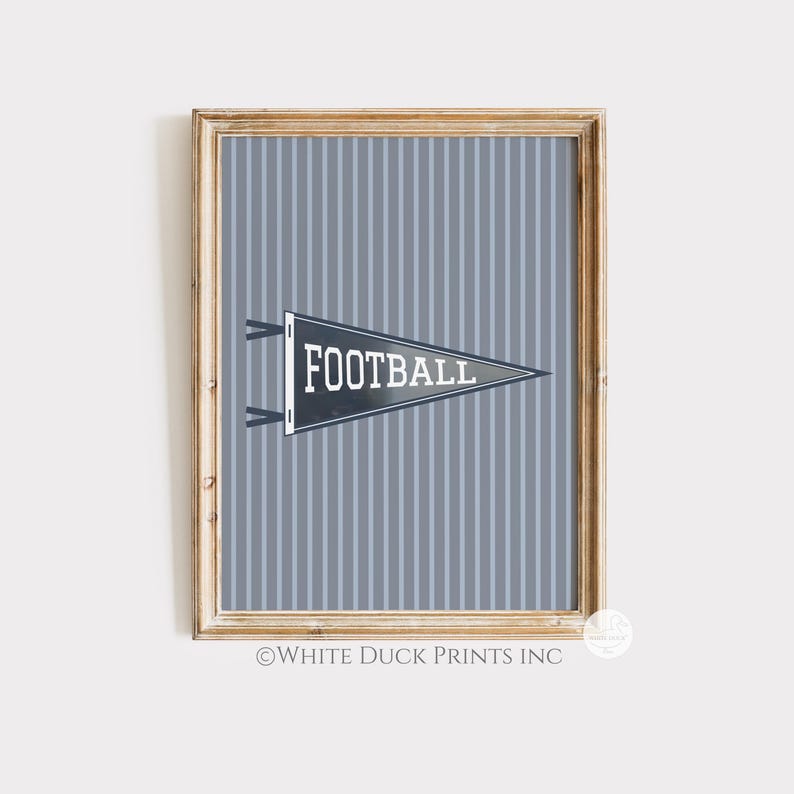 Peut inclure: Impression encadr&eacute;e avec un fanion gris portant le mot "FOOTBALL" en blanc, sur un fond gris &agrave; rayures. L'impression est dans un cadre en bois, adapt&eacute;e &agrave; la d&eacute;coration sur le th&egrave;me du sport.