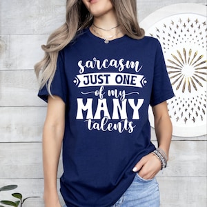 May include: A navy blue t-shirt with white text that reads "sarcasm just one of my many talents".