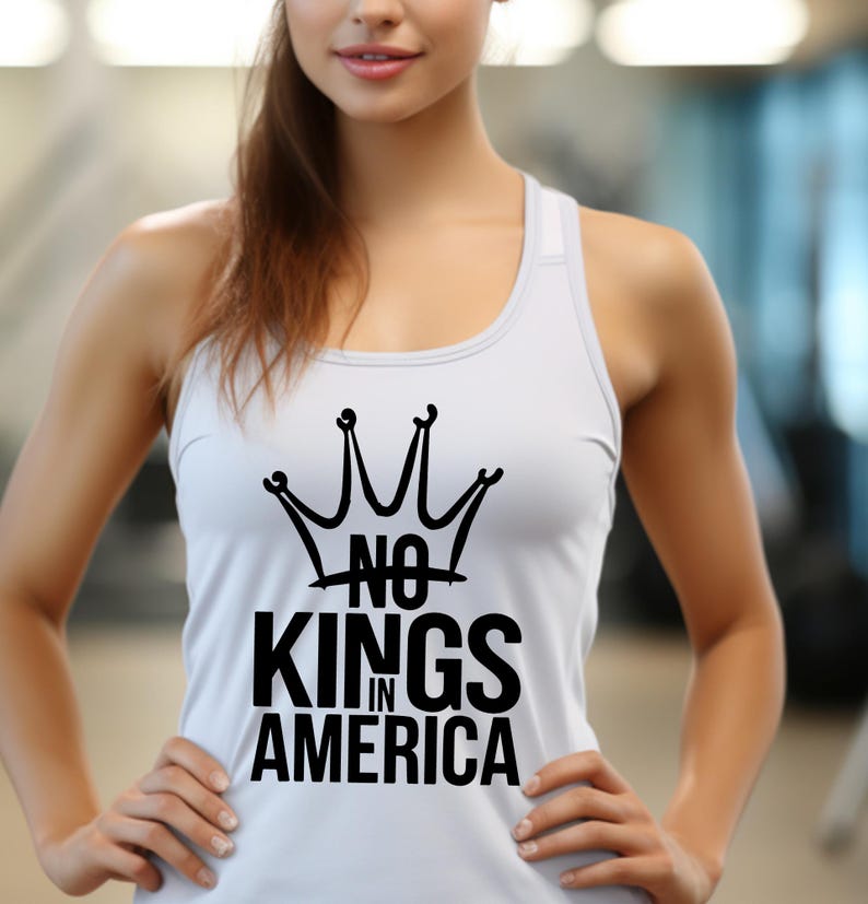 May include: A white vest top featuring a black crown design and the words "NO KINGS IN AMERICA". The sleeveless top has a racerback style. The text is in a bold, sans-serif font.