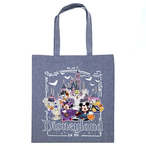 May include: A blue tote bag featuring a Disneyland Halloween design. The graphic includes Mickey Mouse, Minnie Mouse, Donald Duck, Goofy, and other characters in Halloween costumes in front of a castle. The text "Disneyland Est. 1955" is also visible.
