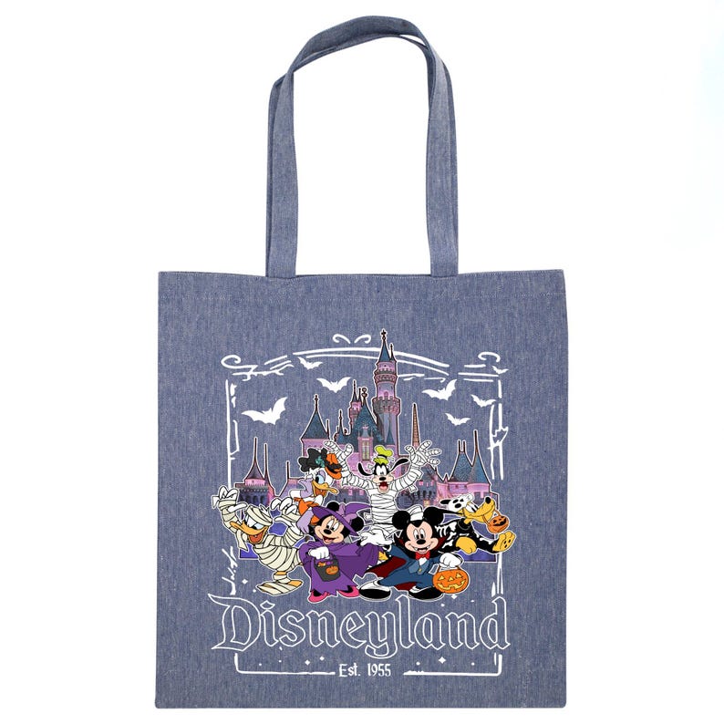 May include: A blue tote bag featuring a Disneyland Halloween design. The graphic includes Mickey Mouse, Minnie Mouse, Donald Duck, Goofy, and other characters in Halloween costumes in front of a castle. The text "Disneyland Est. 1955" is also visible.