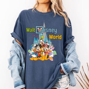 Puede incluir: Camiseta azul marino con el texto "Walt Disney World" y un gr&aacute;fico de personajes de Disney y el castillo de Cenicienta. El dise&ntilde;o incluye Mickey Mouse, Minnie Mouse, Donald Duck, Goofy y Daisy Duck.
