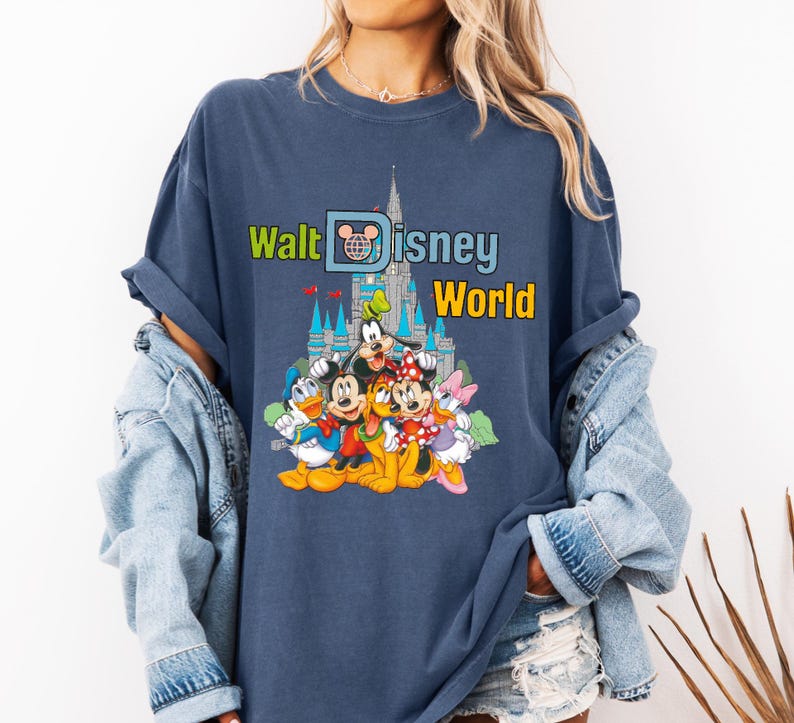 Puede incluir: Camiseta azul marino con el texto "Walt Disney World" y un gr&aacute;fico de personajes de Disney y el castillo de Cenicienta. El dise&ntilde;o incluye Mickey Mouse, Minnie Mouse, Donald Duck, Goofy y Daisy Duck.