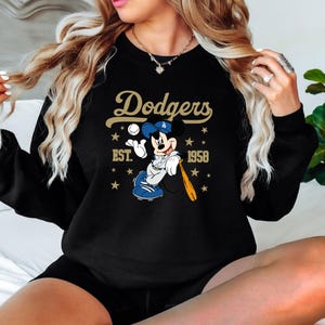 May include: A white ceramic mug with a black handle and the text "But First, Coffee" in a black, handwritten-style font. The mug is on a white surface.