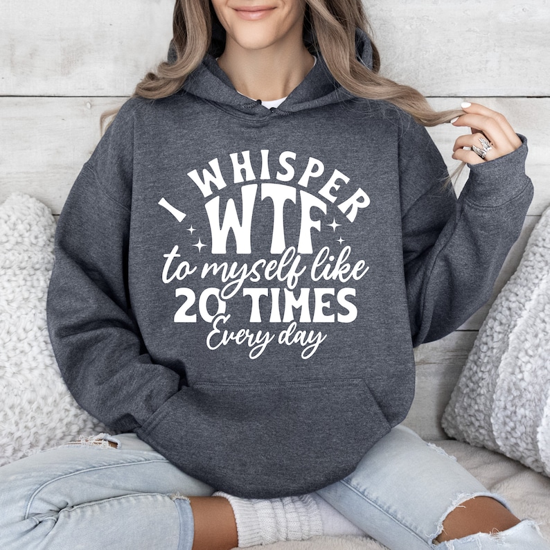 May include: A dark gray hooded sweatshirt with the text "I whisper WTF to myself like 20 TIMES Every day" printed in white.