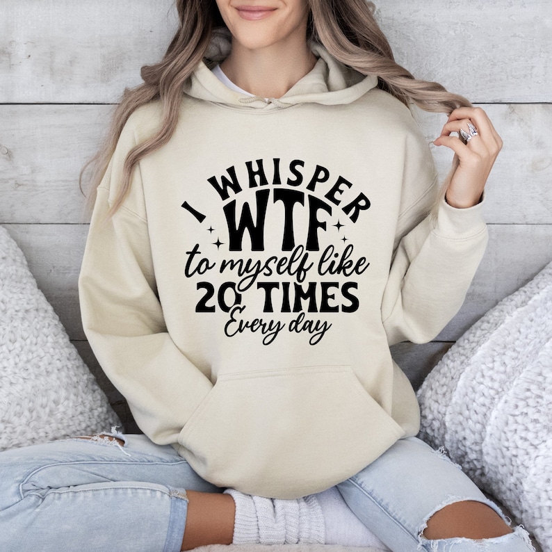 May include: A cream-colored hoodie with a black graphic that reads "I whisper WTF to myself like 20 TIMES every day".