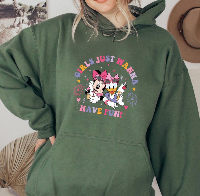 May include: Green hooded sweatshirt with a graphic print of Minnie Mouse and Daisy Duck. The graphic features the text "Girls Just Wanna Have Fun!" in a colorful retro font.