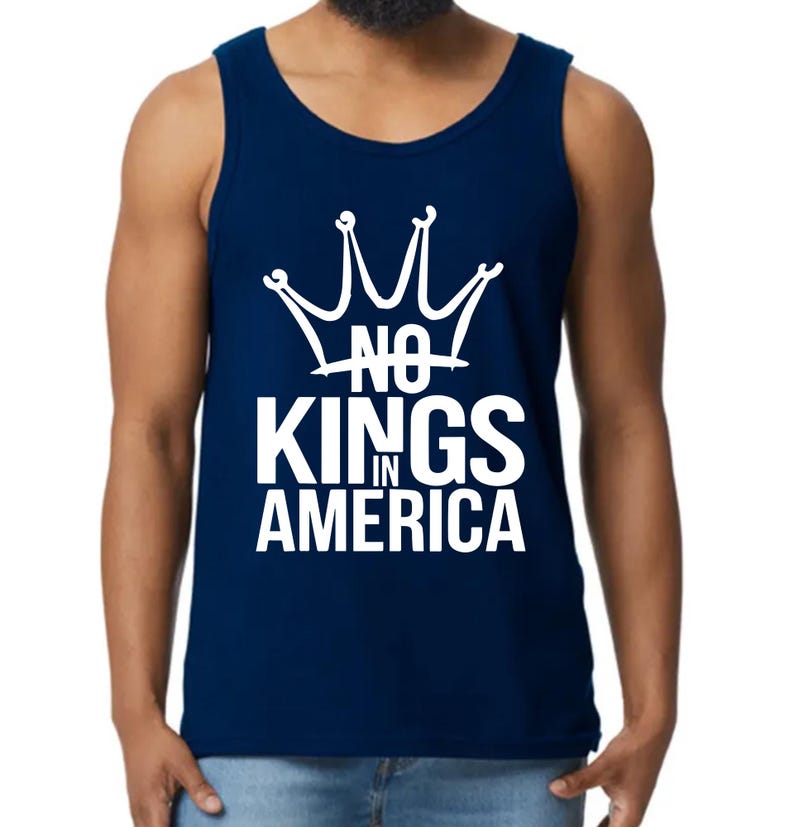 May include: A navy blue vest top featuring the white text "NO KINGS IN AMERICA" under a white crown graphic. The top is sleeveless and made of a soft fabric.