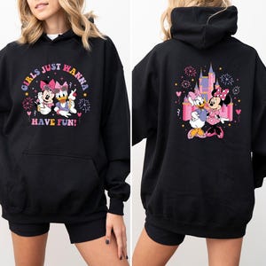 May include: Black hoodie with a graphic print of Minnie Mouse and Daisy Duck in front of a pink castle. The text "Girls Just Wanna Have Fun!" is printed on the front of the hoodie.