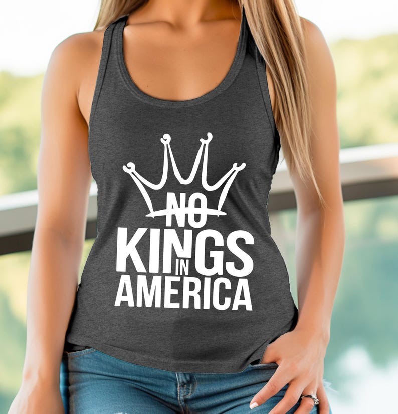 May include: Dark grey racerback vest top featuring the white text "NO KINGS IN AMERICA" and a crown graphic. The vest top is made of a soft material and has a scoop neck.