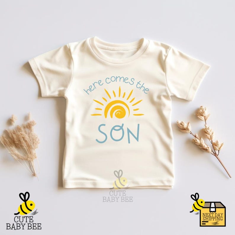 a baby t - shirt that says here comes the son