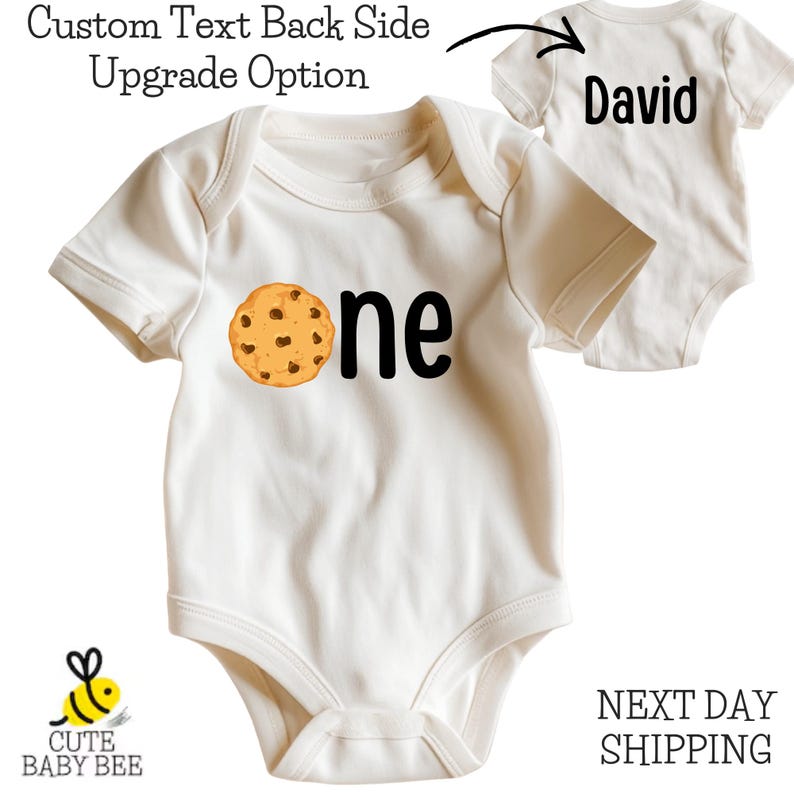 A white baby onesie with a cookie-themed design, featuring the text "One" and the name "David" printed on it.