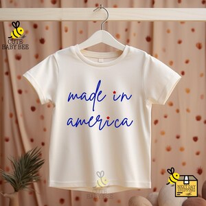 a t - shirt that says made in america hanging on a clothes line