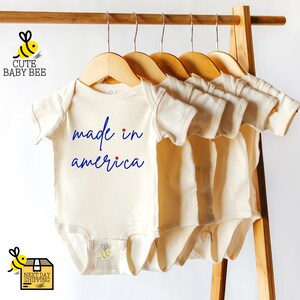 a baby's bodysuit hanging on a clothes rack