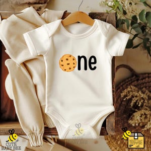 a baby bodysuit with a cookie on it