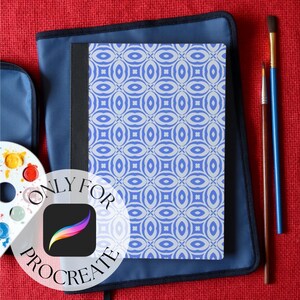 Procreate mock ups by GigiLYL, showing a composition notebook cover with paint brushes and other back to school art supplies, against a red hessian burlap background