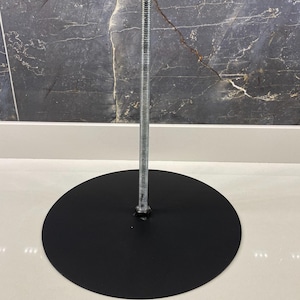 May include: A black metal stand with a round base and a threaded metal rod.