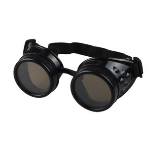 May include: Black goggles featuring two circular, dark-tinted lenses encased in a glossy black frame. The side panels have a textured, geometric pattern, and the eyewear is secured with an adjustable black elastic strap for a snug fit.