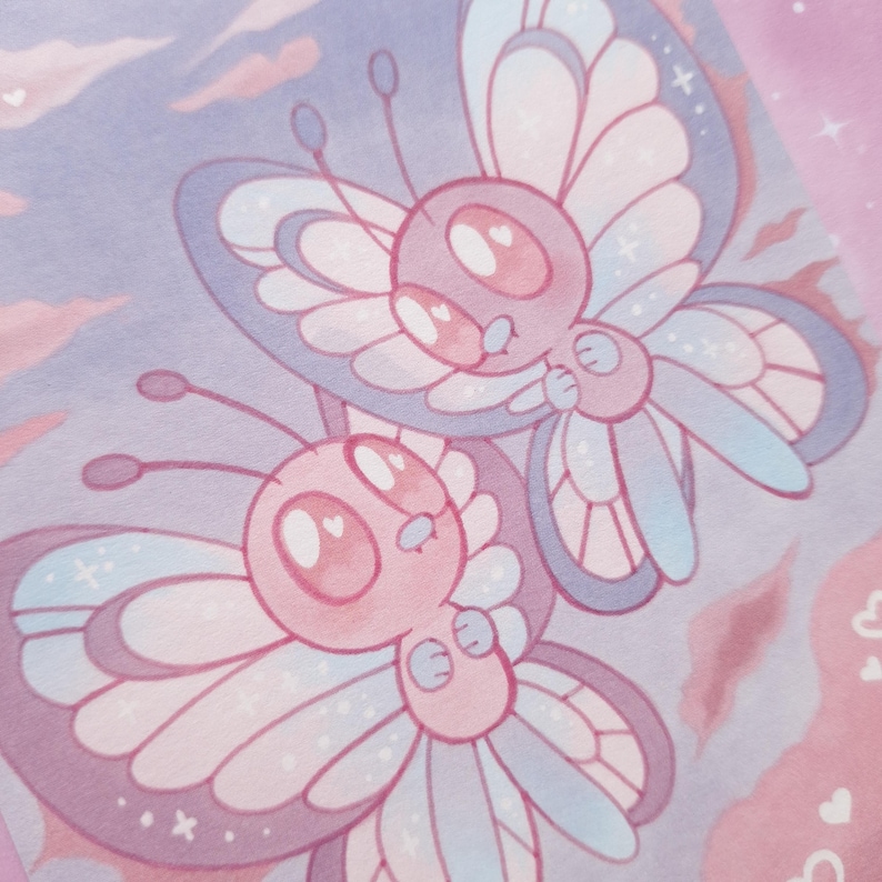 May include: A charming illustration depicts two cartoon butterflies in flight. The butterflies are predominantly pink and blue, with detailed wing patterns and antennae. The background is a soft blend of pink and purple, creating a dreamy, pastel aesthetic, reminiscent of a children's book.