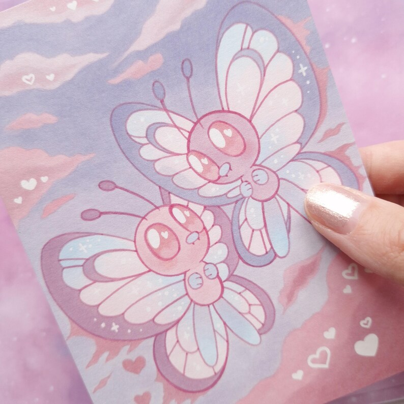 May include: A pastel illustration of two cartoon butterflies in pink and lavender, with light blue accents. The butterflies have large eyes and heart-shaped pupils. The background features pink clouds and small hearts.