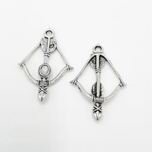 May include: Two silver bow and arrow charms with a clear rhinestone in the center of each arrow.
