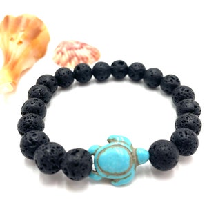 May include: Black lava rock beaded bracelet with a turquoise turtle charm.