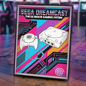 May include: Framed poster featuring a retro SEGA Dreamcast gaming system. The artwork includes a white game console and controller, connected by a cable, set against a vibrant background of pink, blue, purple, and orange geometric shapes. The text reads "SEGA DREAMCAST THE ULTIMATE GAMING SYSTEM."