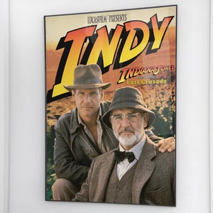 May include: A framed movie poster for "Indiana Jones and the Last Crusade." The poster features Harrison Ford and Sean Connery. The title "INDY" is in large yellow letters, with the film title below. The poster is in a black frame.