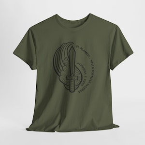 Peut inclure: T-shirt vert olive avec un motif noir d'une épée ailée, l'année 1942 et du texte italien. Le texte se lit « EL ALAMEIN - NELLA FORTUNA AVVERSA, VITTORIOSA E FIERA ».