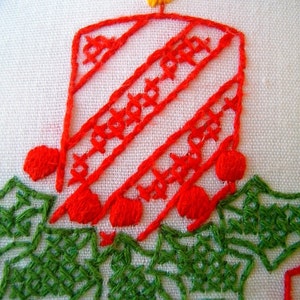 May include: Embroidered Christmas candle design with a red candle, yellow flame, and green holly. The candle has diagonal stripes and cross-stitch details. Blue and red accents complete the festive look.