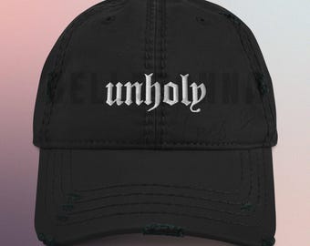 May include: Black distressed baseball cap with the word "unholy" embroidered in white on the front.