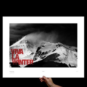 May include: Black and white photograph of a snow-covered mountain range under a dark, cloudy sky. Bold red text reads "VIVA LA WINTER" across the lower left. The image is printed on white paper.