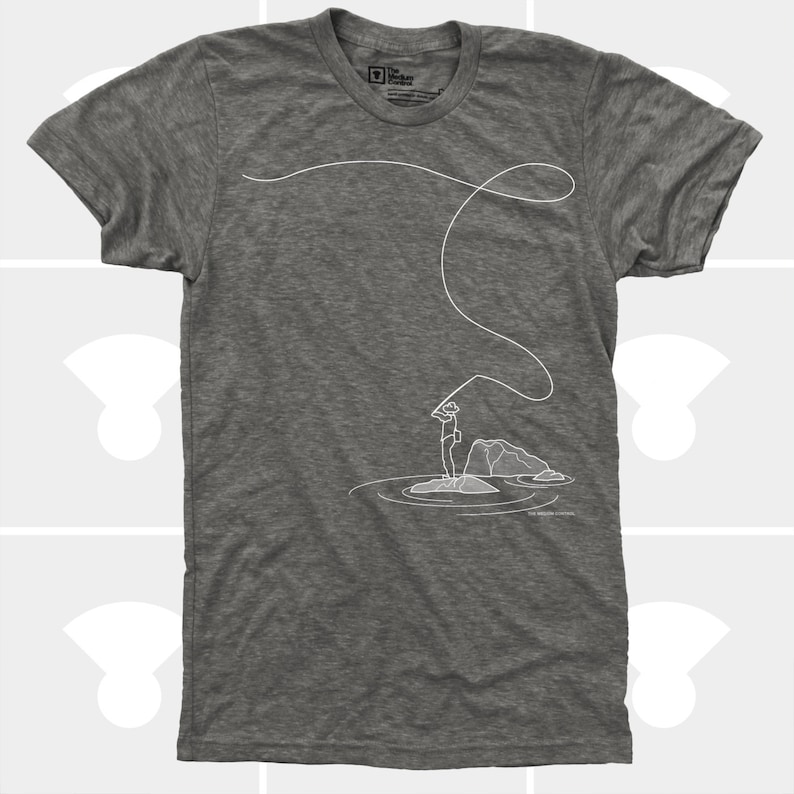 May include: Heather gray t-shirt featuring a white line drawing of a person fly fishing. The illustration shows the person standing on a rock in the water, casting a line. The shirt has a crew neck and short sleeves.