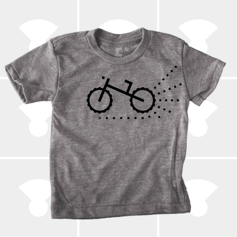Puede incluir: Una camiseta gris jaspeada con una silueta negra de una bicicleta con un rastro de puntos detr&aacute;s.