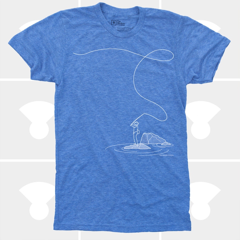 May include: Blue t-shirt with a white line drawing of a person fly fishing. The illustration shows a person standing on a rock in water, casting a line. The shirt has a crew neck and short sleeves.