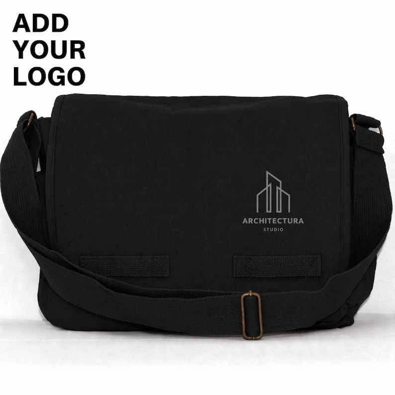 May include: Black messenger bag with a flap closure and adjustable shoulder strap. The bag features a silver logo and the text "ARCHITECTURA STUDIO". The top left corner of the bag has the text "ADD YOUR LOGO".