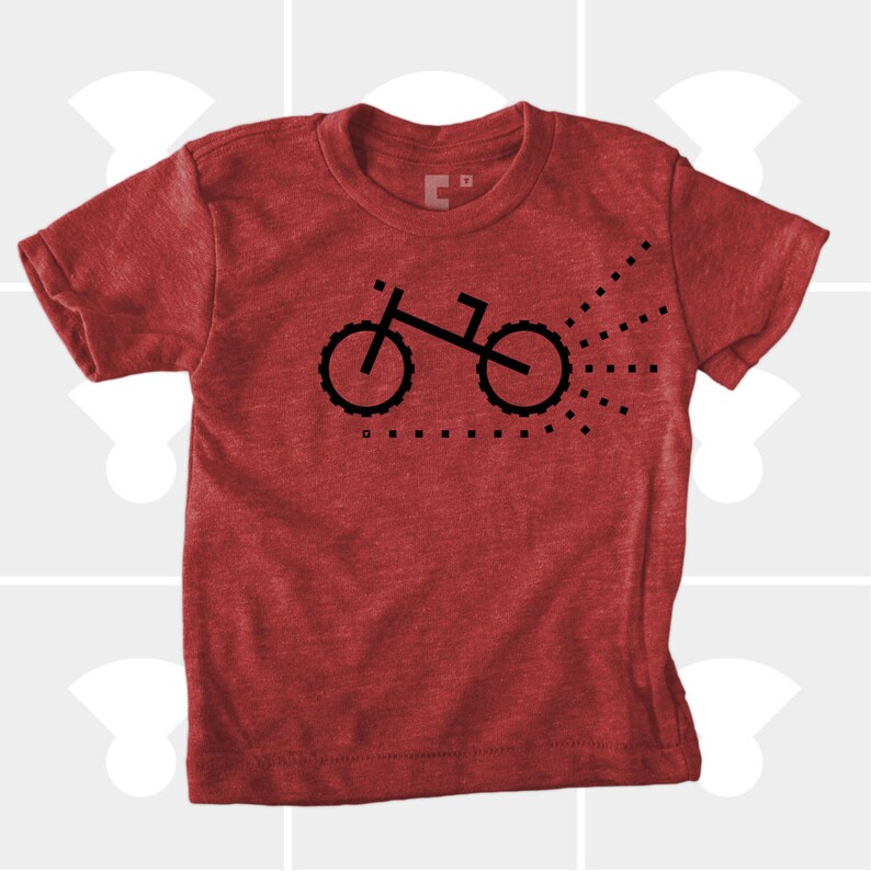 Puede incluir: Camiseta roja con un gr&aacute;fico negro de una bicicleta con un rastro de puntos detr&aacute;s.