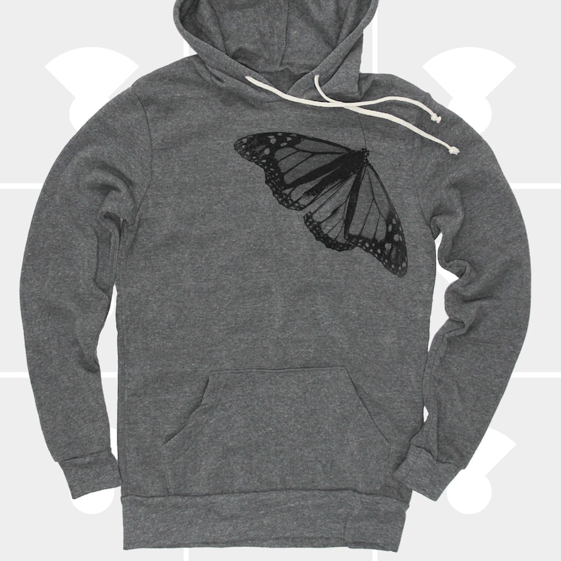 Op de afbeelding: Een donkergrijze hoodie met een zwarte vlinderprint op de voorkant. De vlinder is gecentreerd op de borst en kijkt naar rechts.
