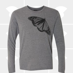Op de afbeelding: Een grijs longsleeve t-shirt met een zwarte vlinderprint.