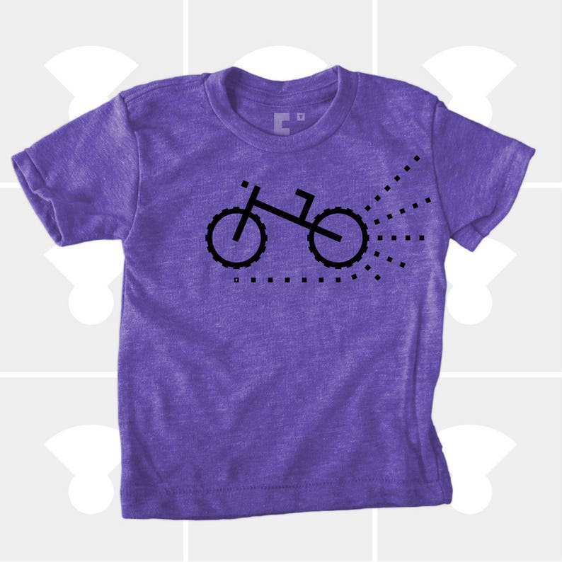 Puede incluir: Camiseta de manga corta de color morado con un gr&aacute;fico negro de una bicicleta con un rastro de puntos detr&aacute;s.