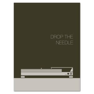 May include: A minimalist print featuring a turntable design in shades of gray and white against a dark olive-green background. The text "DROP THE NEEDLE" is displayed in a clean, sans-serif font above the turntable illustration. The print has a modern aesthetic.