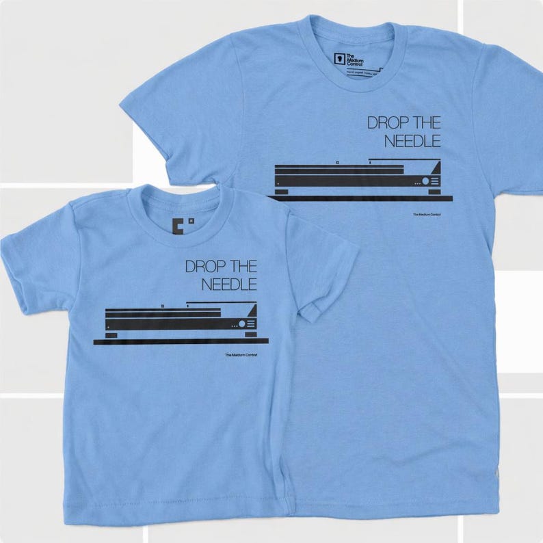 May include: Two light blue t-shirts, one adult and one child size, featuring a black graphic of a record player and the text "DROP THE NEEDLE." The Medium Control logo is at the bottom.
